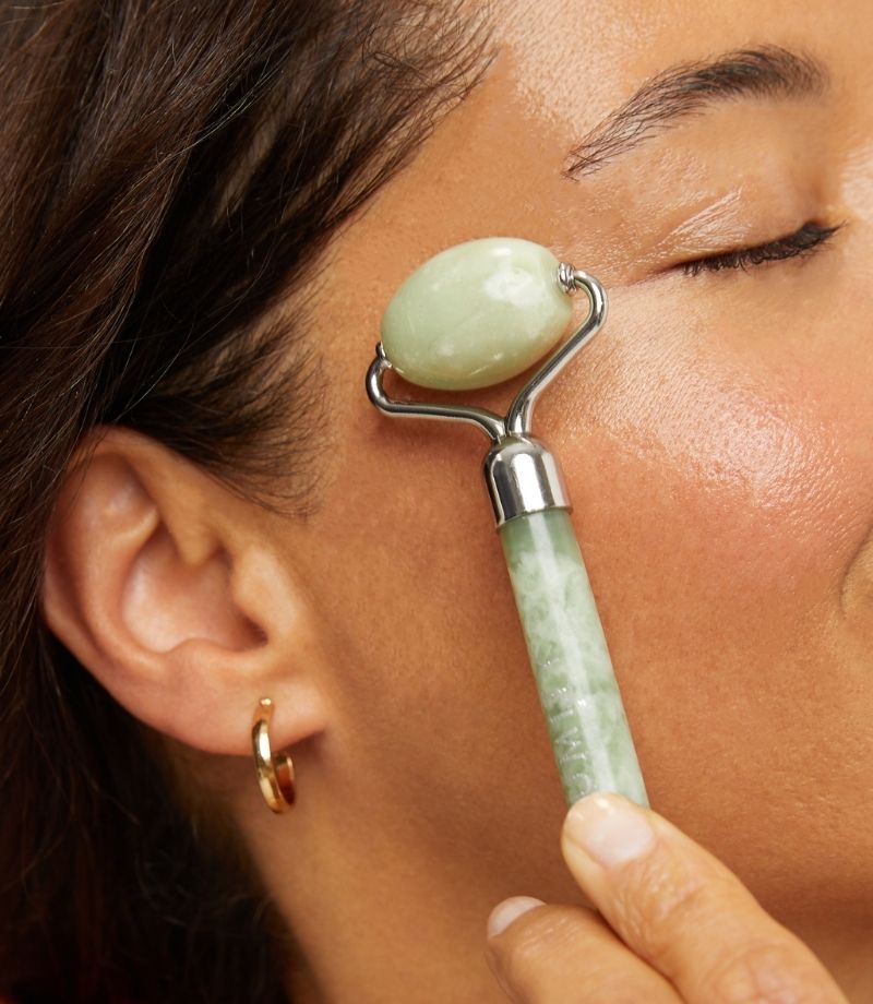 Woman massaging face with Lumity jade roller