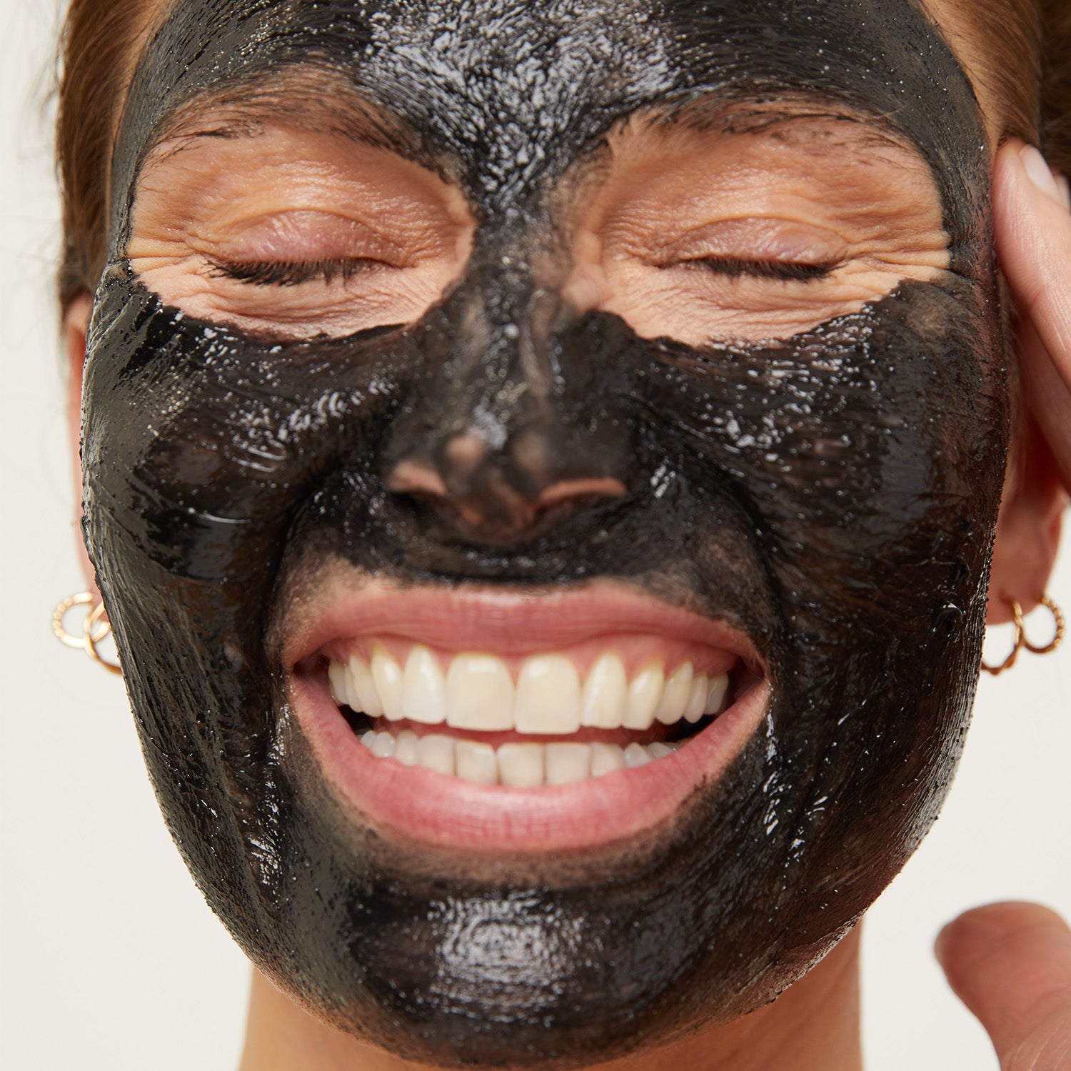 Model smiling with cleanse on face