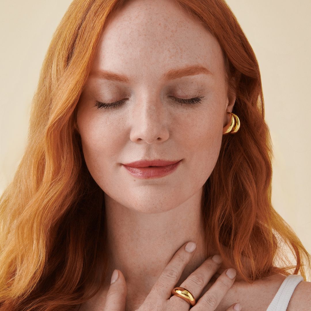 Photo of woman closing her eyes while placing her hand on her chest.