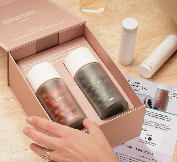 Morning & Night supplement bottles in a box with a hand holding it, on a table with travel cases.