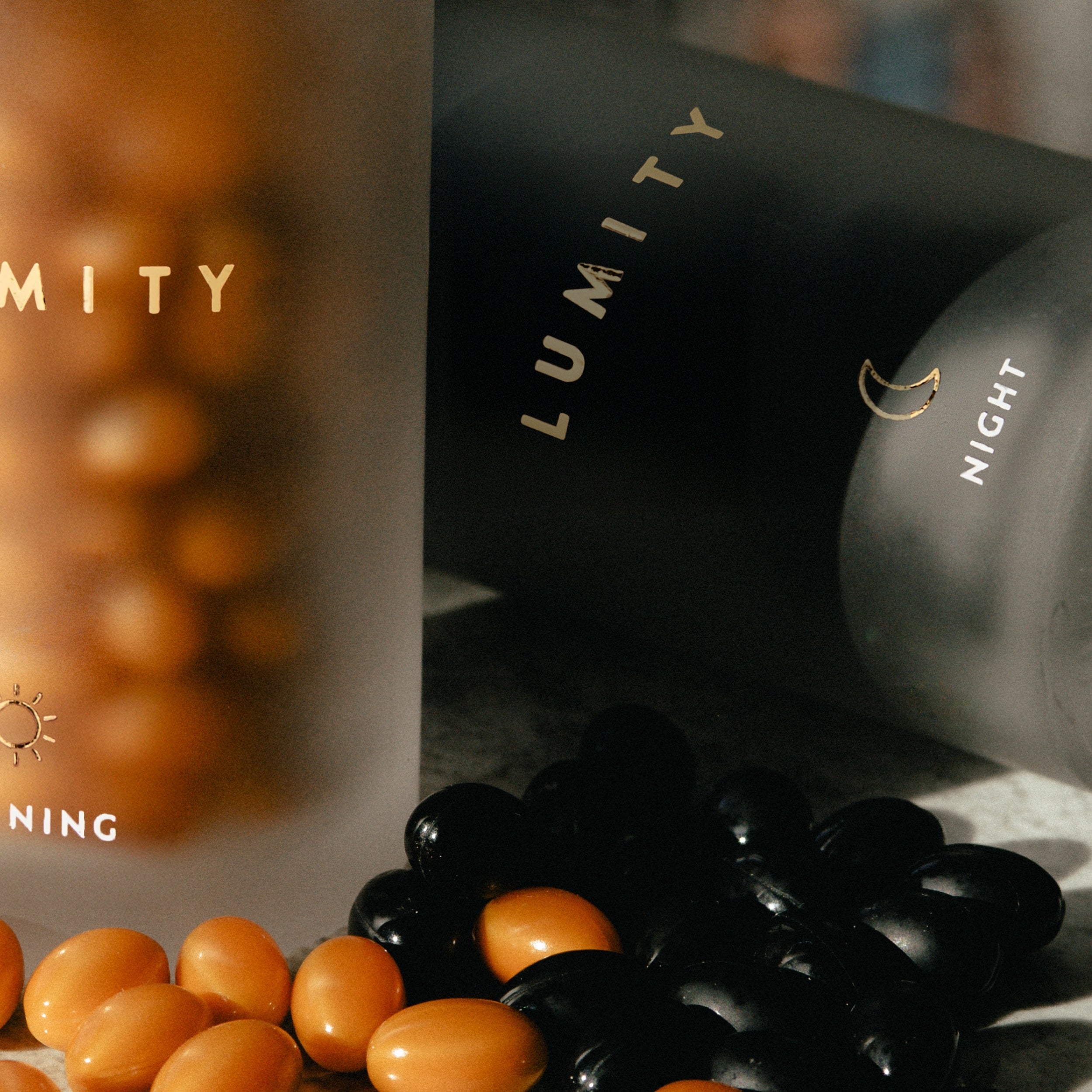 Lumity morning and night supplement bottles with capsules on a dark background
