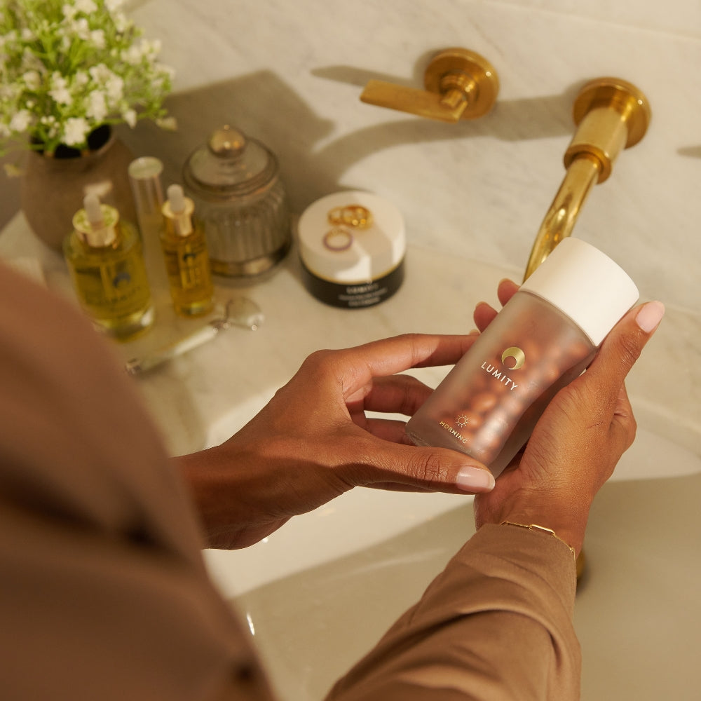 women's morning supplement in models hand, in bathroom