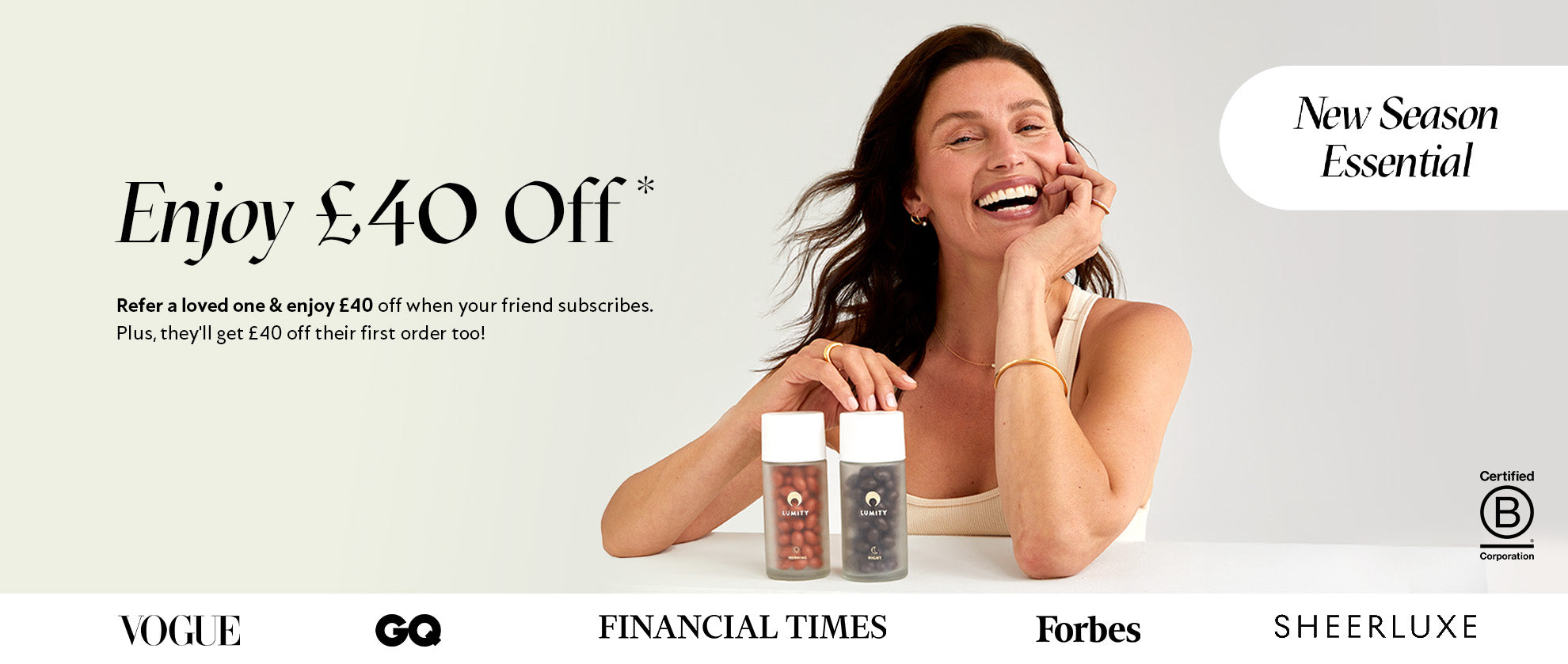 Happy woman in white tank top sitting with two supplement bottles, promoting a new season wellness offer.