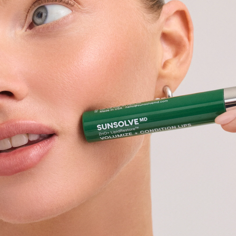 Image of model holding SunsolveMD LipidRestore Lip