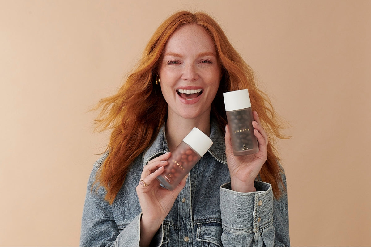 Woman holding Lumity Morning & Night for Women against a beige background