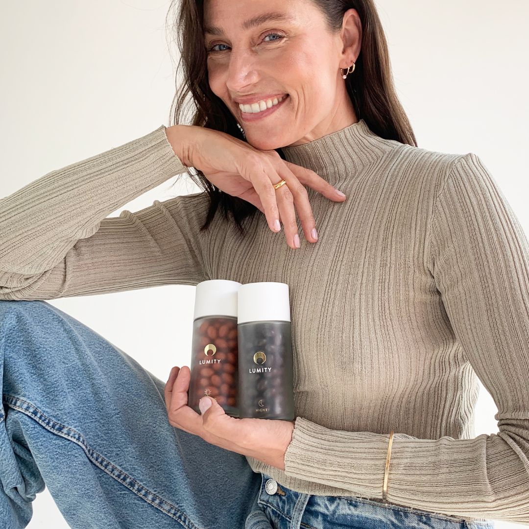 Woman smiling and holding Morning & Night supplement bottles