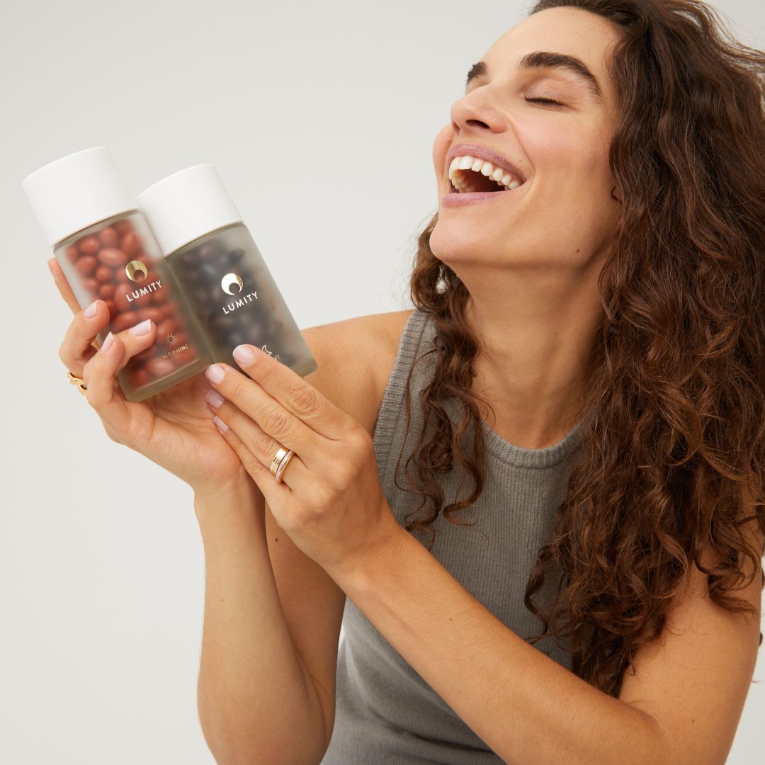 Woman laughing and holding Morning & Night bottles