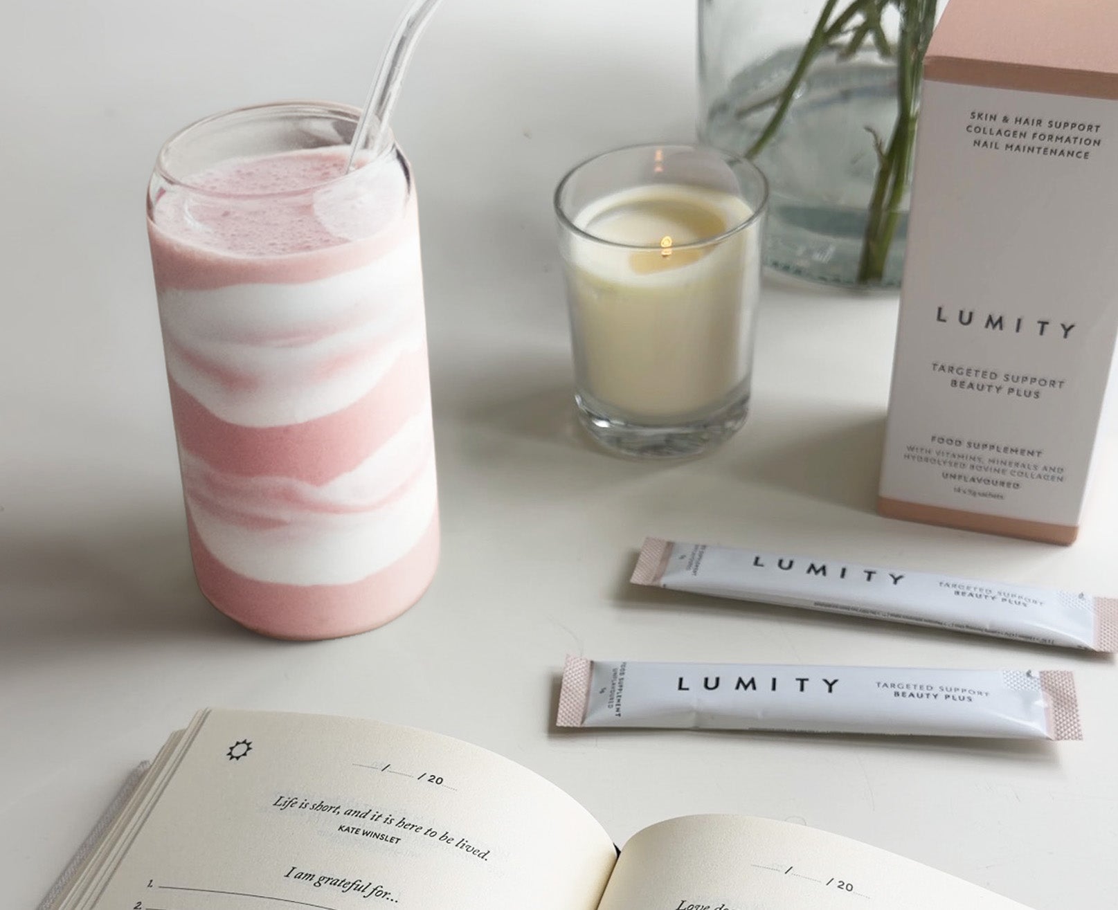 Photo of strawberry smoothie next to Beauty Plus supplements