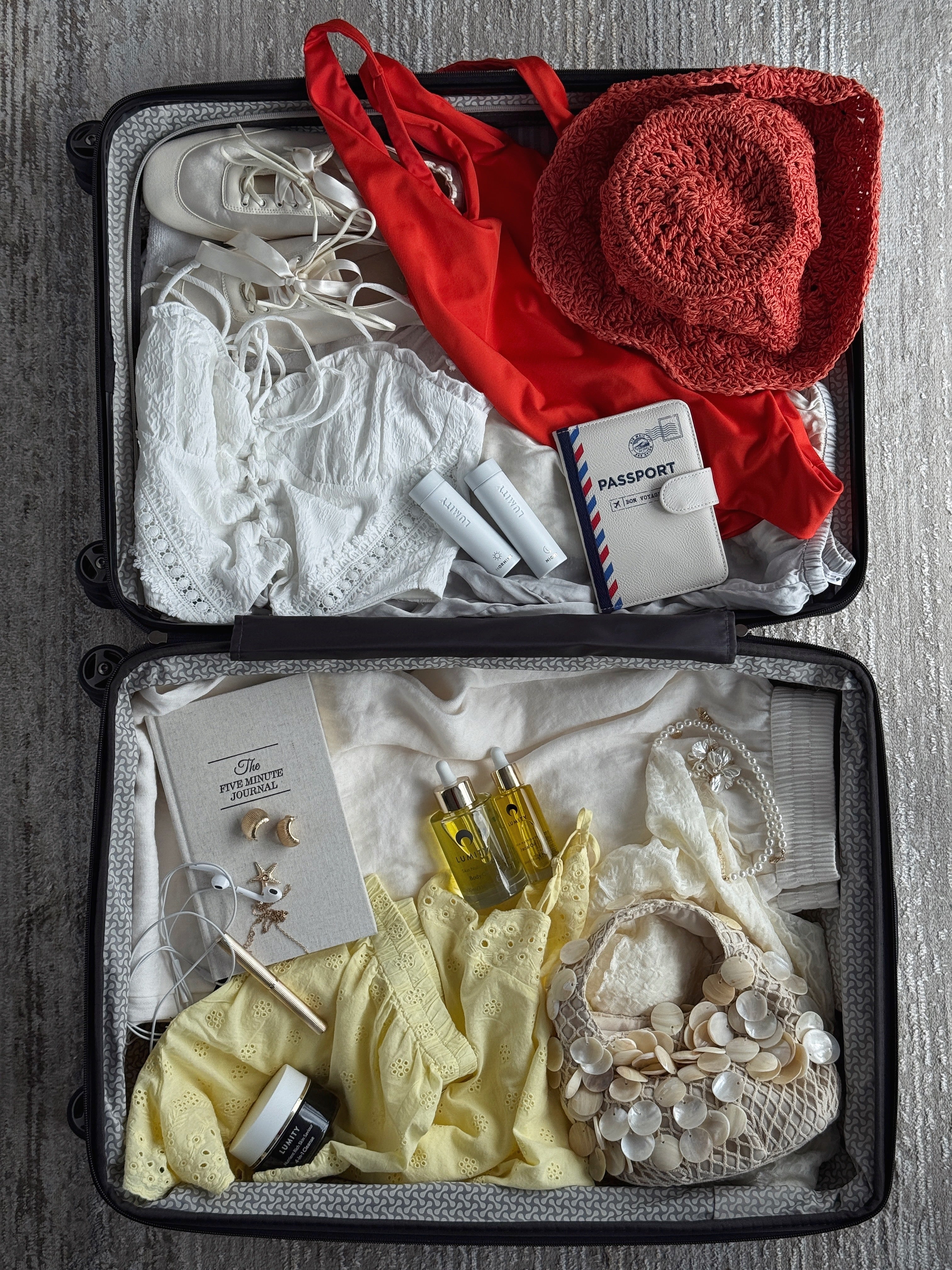 Open suitcase with clothes, accessories and Lumity products