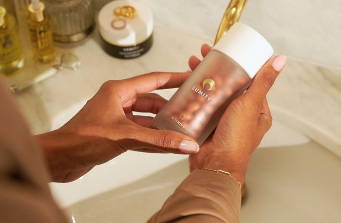 Photo of woman holding Morning bottle over her bathroom sink.