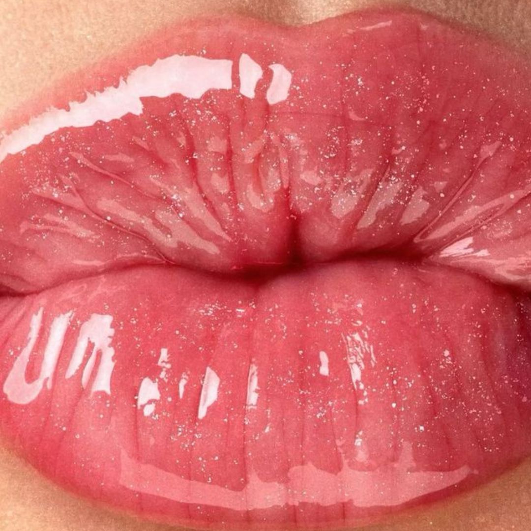 Close-up of lips with glossy pink lip gloss 