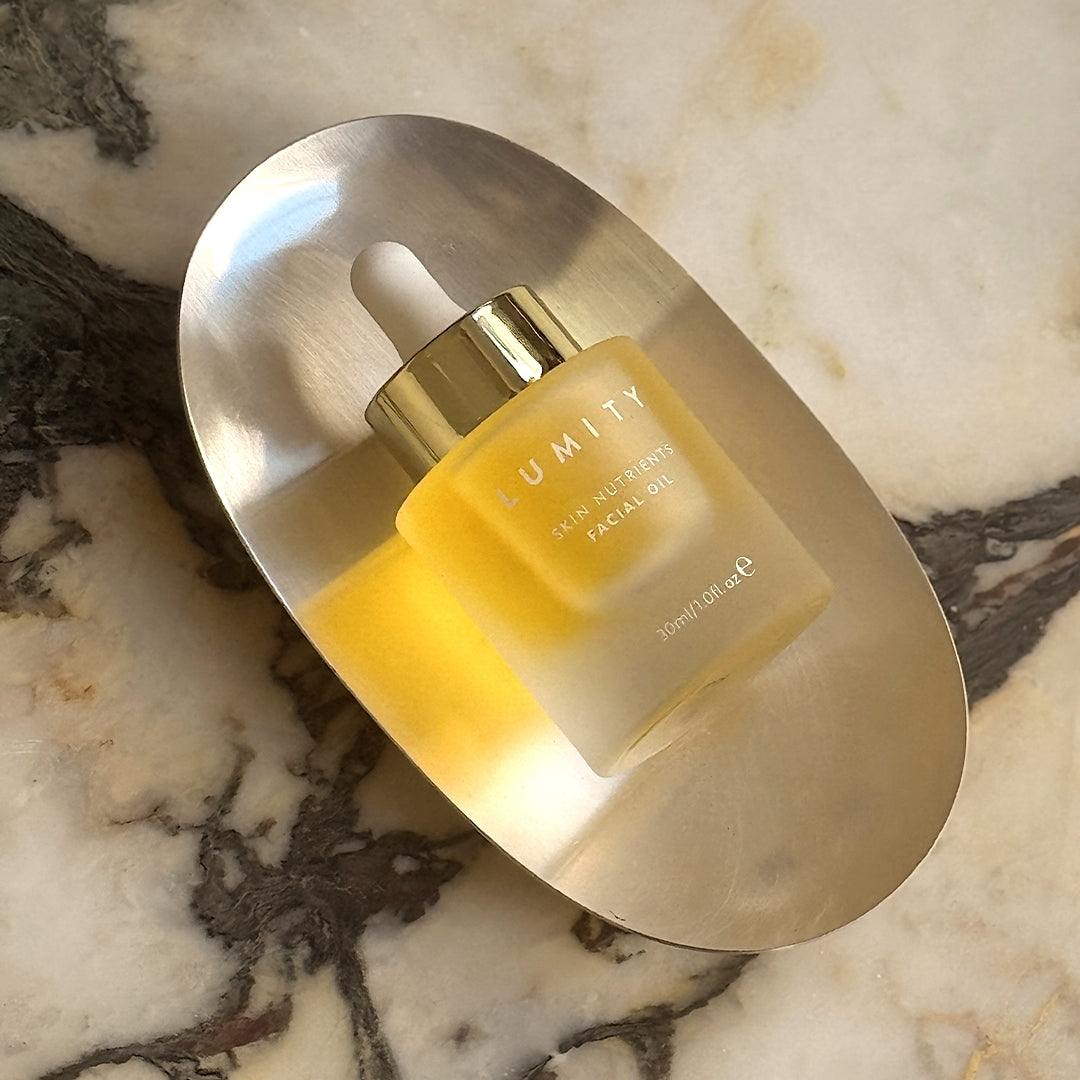 Facial oil bottle on a marble surface