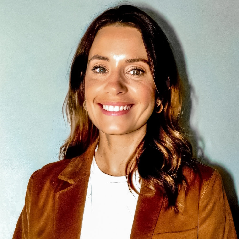Headshot of Natalie Pennicotte_Collier wearing a orange velvet blazer and white t-shirt