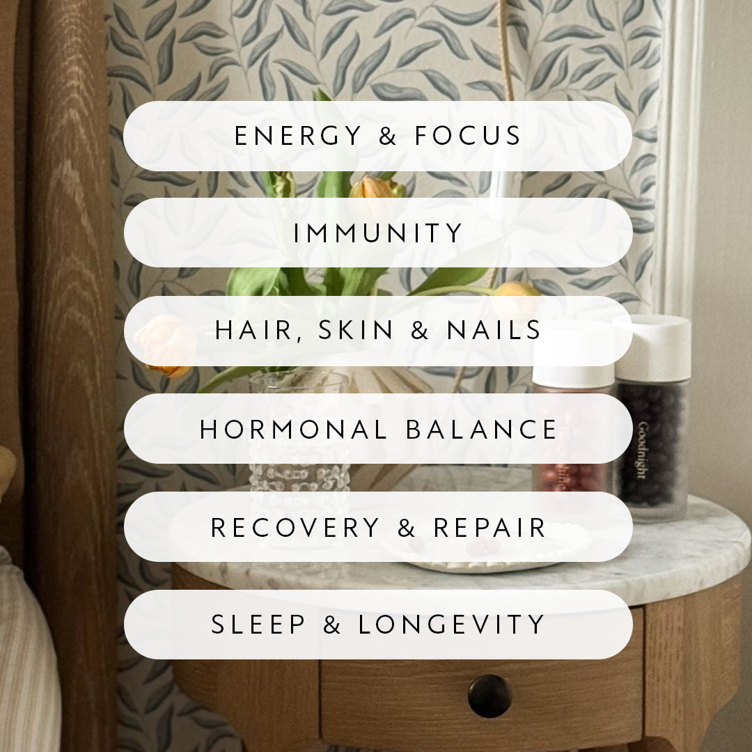 Lumity's Morning & Night glass bottles on a marble side table with a list of health benefits over a blurred background of a dresser and mirror.