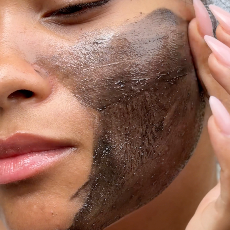 Close up of a woman applying Lumity Skin Nutrients 4-in-1 Cleanse to her face