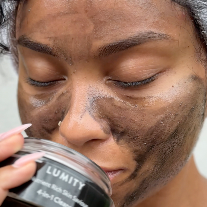 Woman with Lumity Skin Nutrients 4-in-1 Cleanse applied on her face, texture of the cleanser is black charcoal