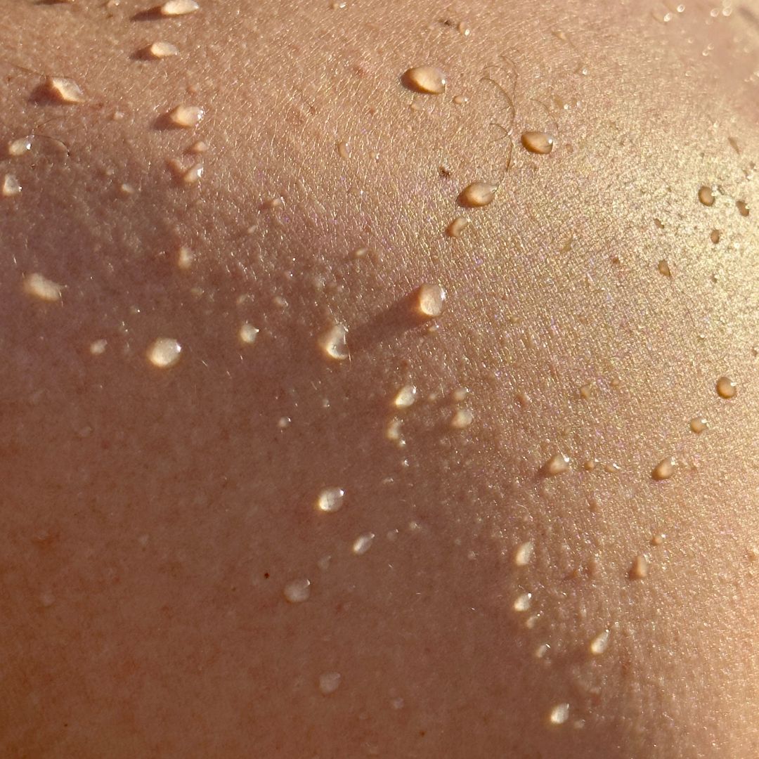 Close-up of skin with small water droplets.