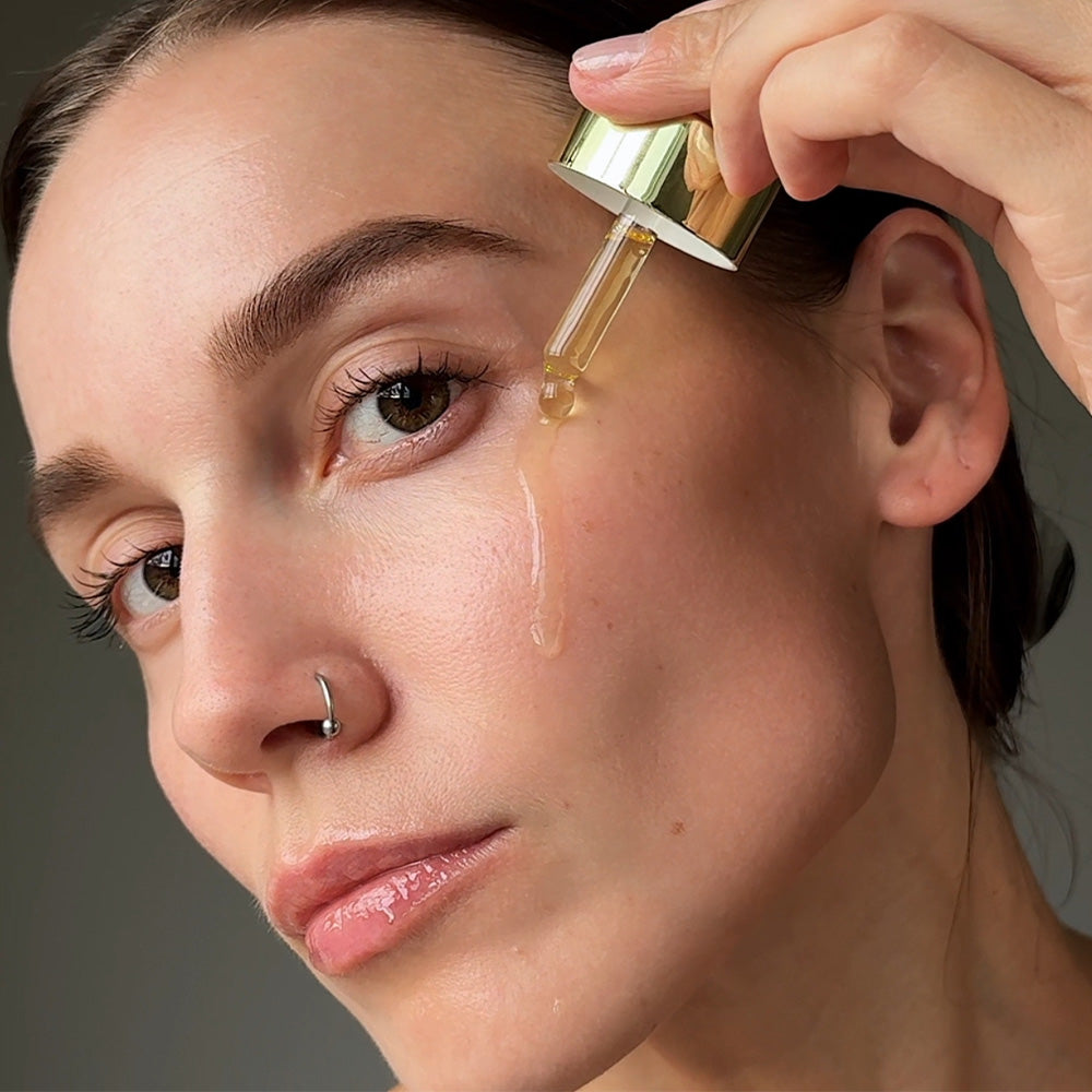 Lumity Skin Nutrients Facial Oil being dropped on womans face