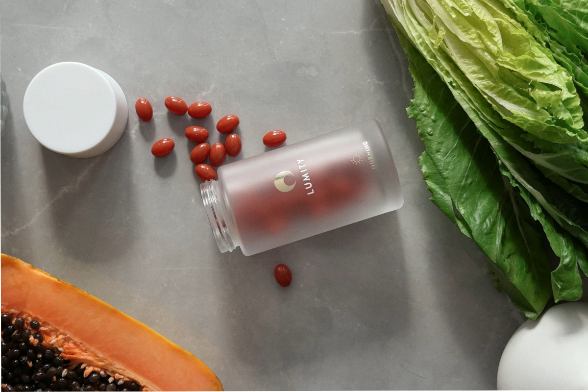Lumity Morning bottle on kitchen counter next to lettuce and papaya