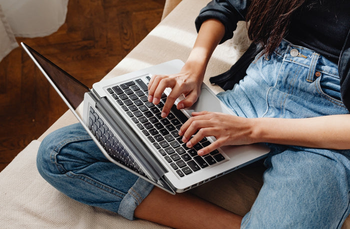 Person using a laptop on a wooden floor