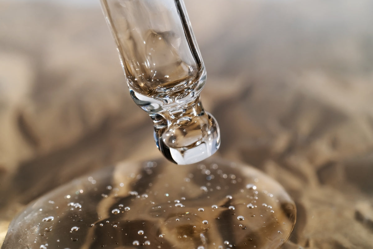 Close-up of a pipette with liquid being dispensed onto a surface with bubbles.
